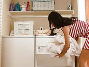 Gorgeous housewife bends over in a short dress doing laundry
